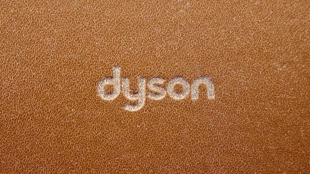 the word dyson written on a brown leather surface