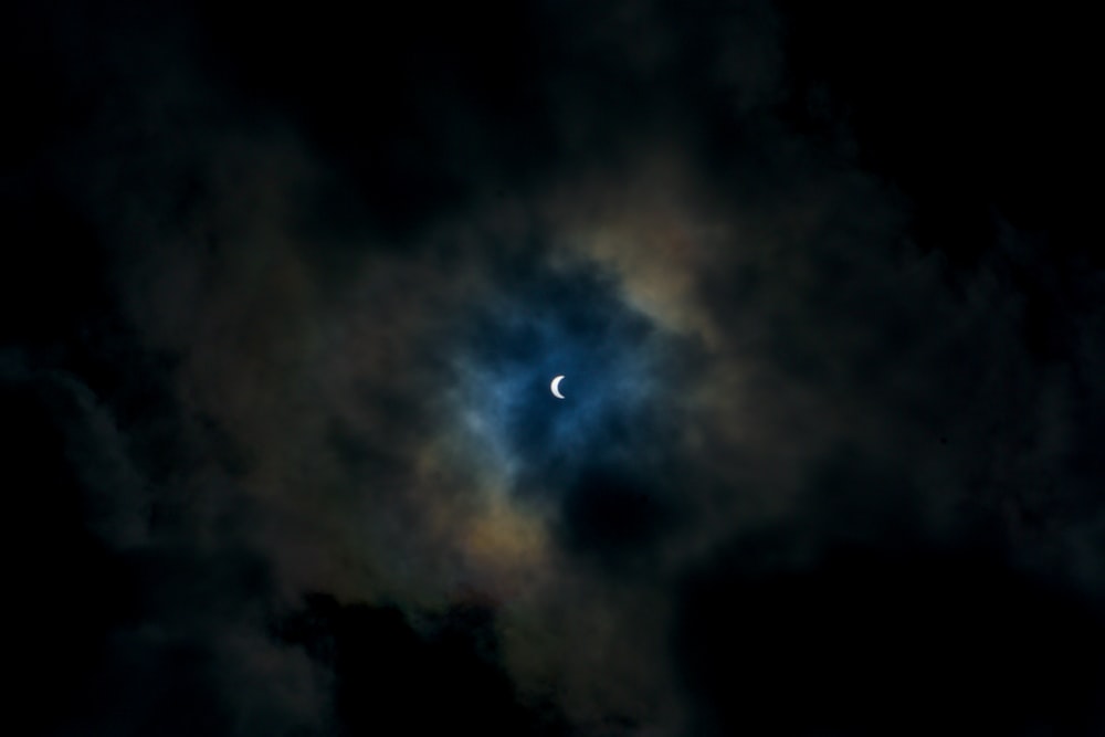 the moon is seen through the clouds in the night sky