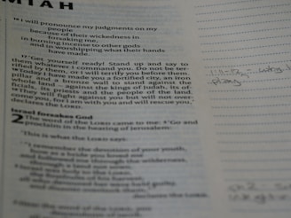 A close-up view of a page from a book, likely religious, featuring printed text and handwritten notes in the margins. The text is formatted in paragraphs with headings, and the notes are written in a light pencil, indicating personal reflections or study points.