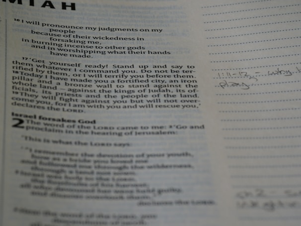 A close-up view of a page from a book, likely religious, featuring printed text and handwritten notes in the margins. The text is formatted in paragraphs with headings, and the notes are written in a light pencil, indicating personal reflections or study points.