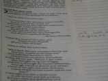 A close-up of an open Bible with handwritten song lyrics and musical notes on the pages.