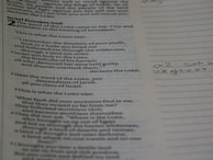 Close-up of an open Bible with highlighted verses and handwritten notes on the side.