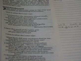 Close-up of an open Bible with highlighted passages and handwritten reflections.
