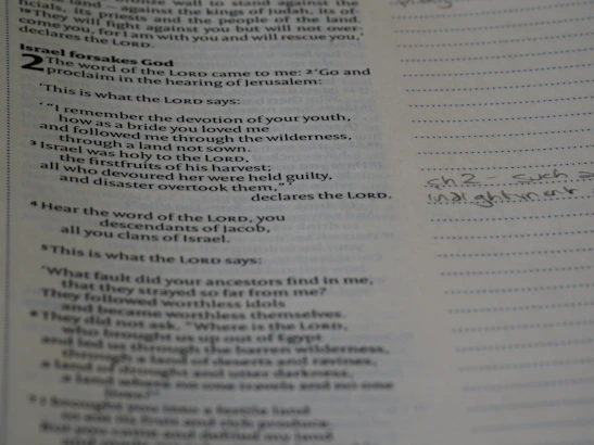 Close-up of an open Bible with highlighted passages and handwritten notes on the margins.