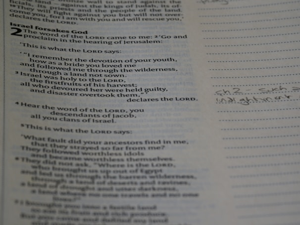 Close-up of an open Bible with highlighted passages and handwritten reflections.