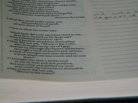 The image shows a page from a book with religious text, likely a Bible, featuring scriptural passages. The text includes questions posed as statements and mentions of the Lord and ancestors. On the right side, there's a lined margin with handwritten notes.