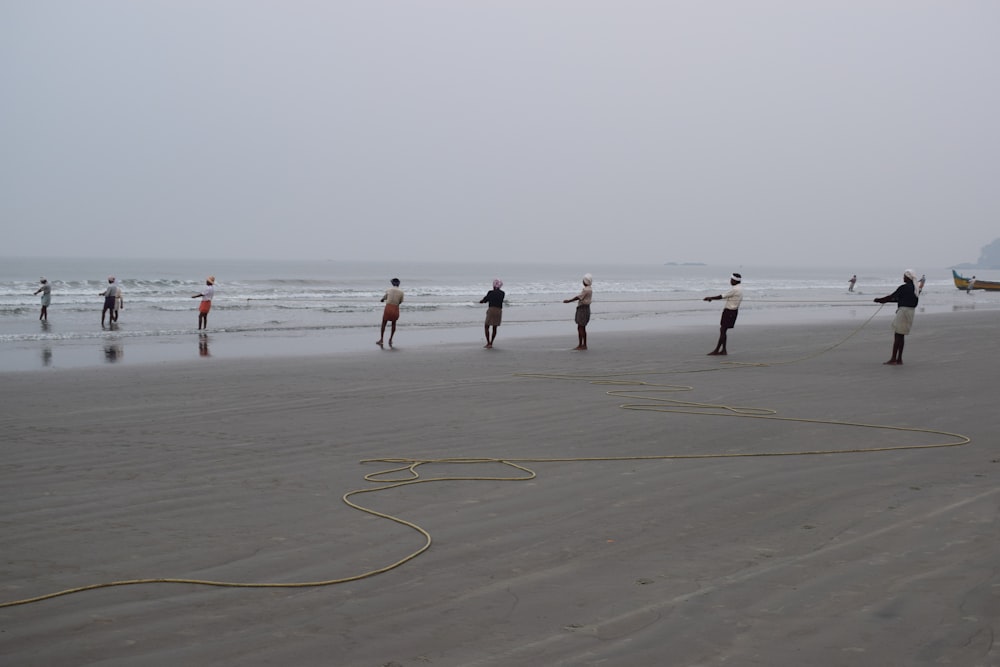 a group of people standing on top of a beach