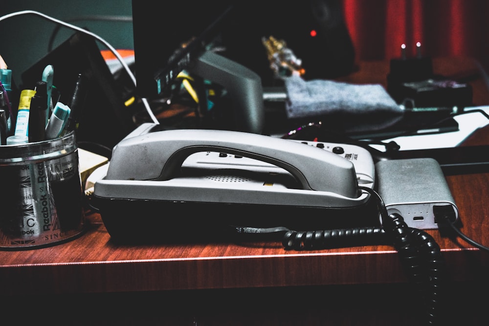 a desk with a phone, pencils, pens, and other office supplies