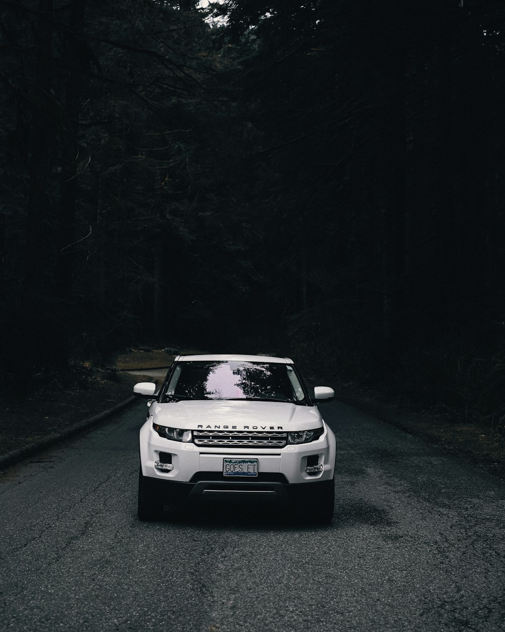 a white range rover parked on the side of a road