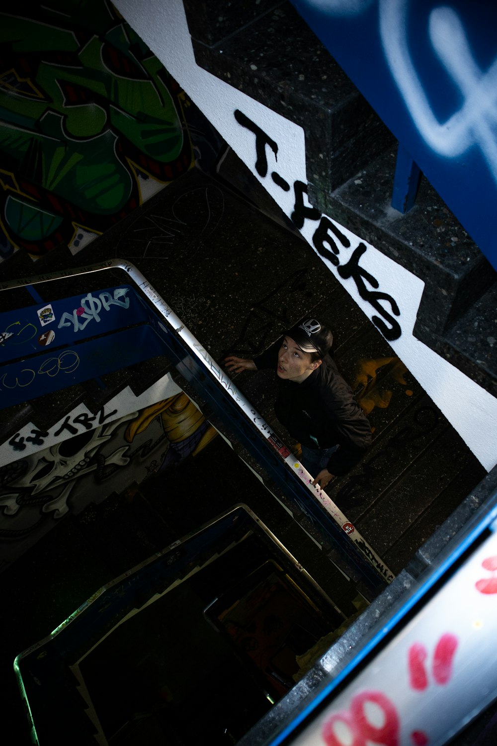 a man standing in front of a wall covered in graffiti