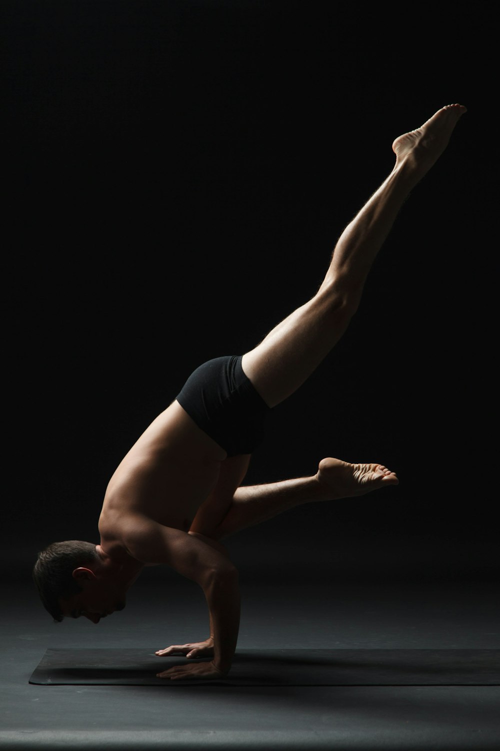 a man doing a handstand in the dark