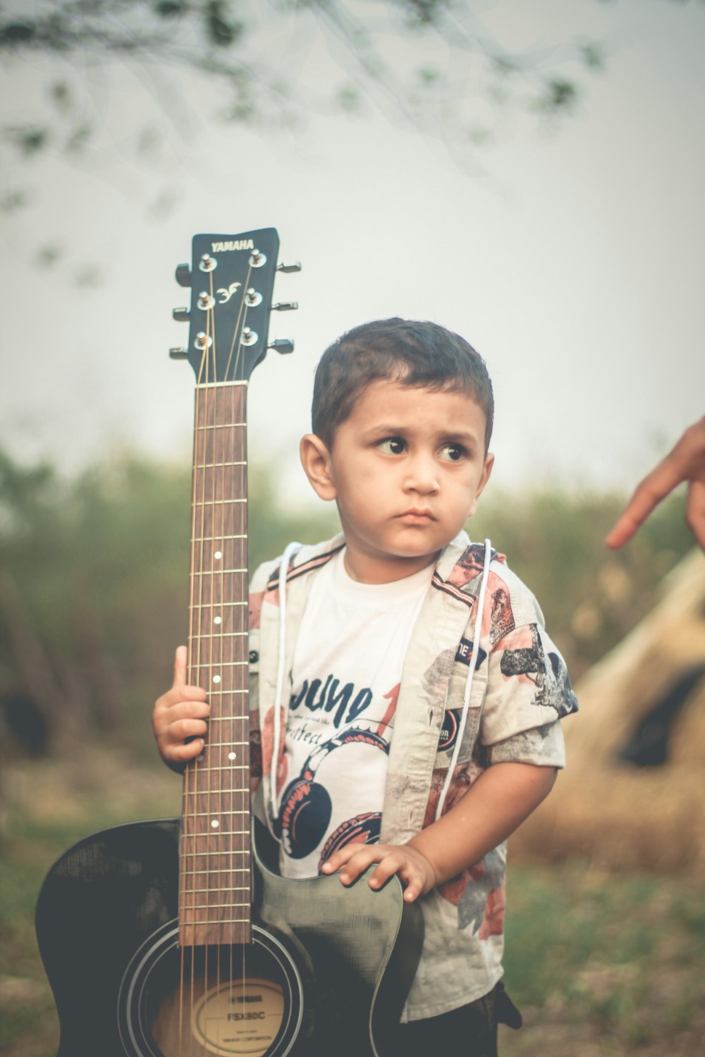 a young boy holding a guitar in his hands