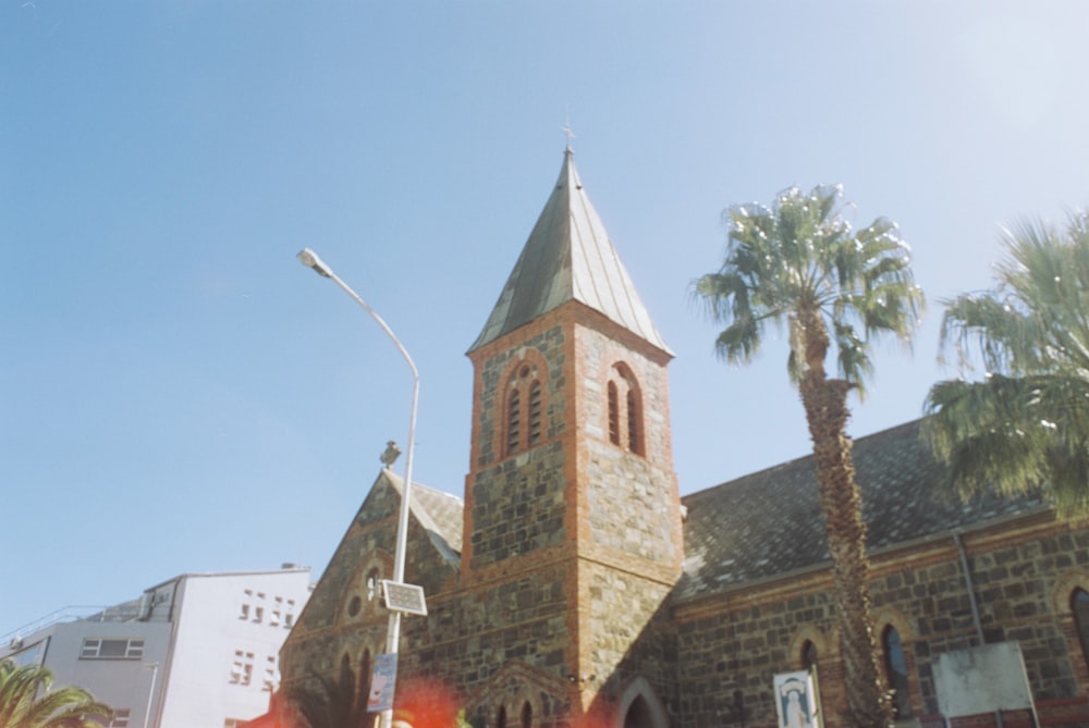 a church with a tall steeple surrounded by palm trees