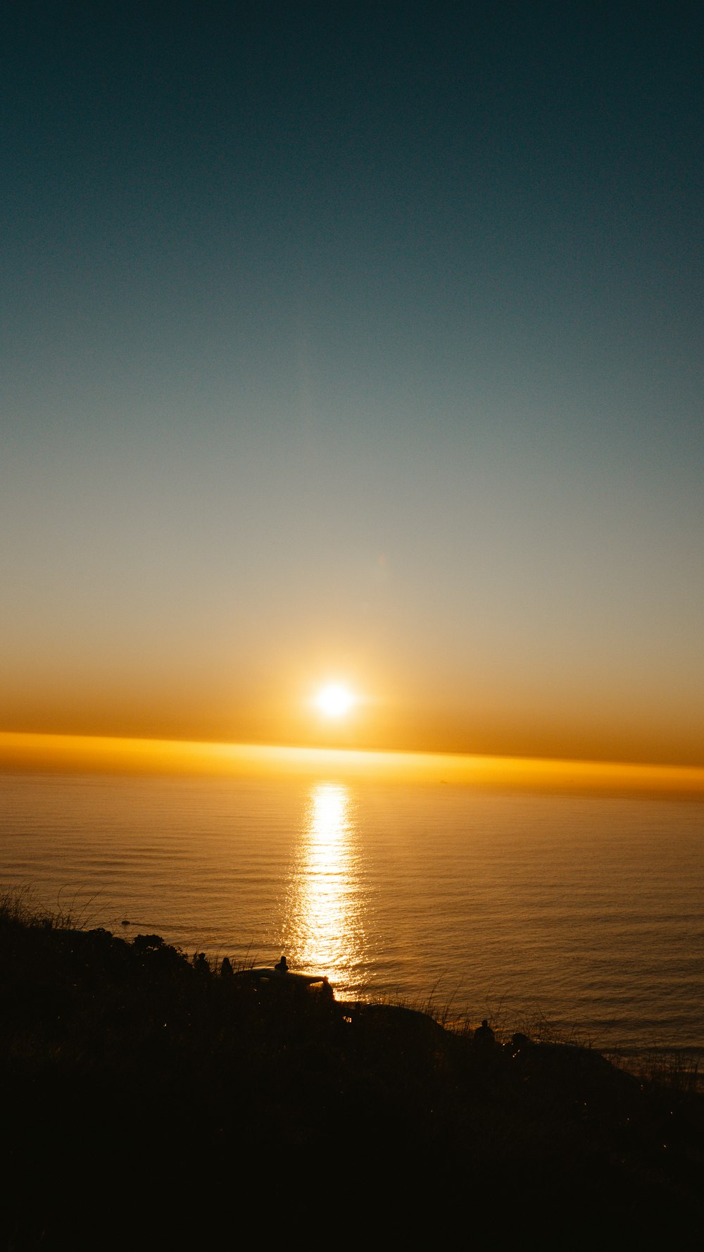 the sun is setting over the ocean on a clear day