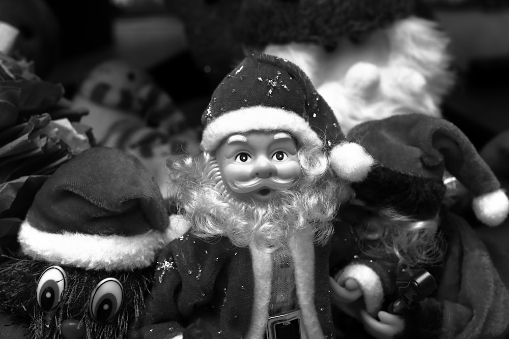 a black and white photo of a group of santa clause dolls