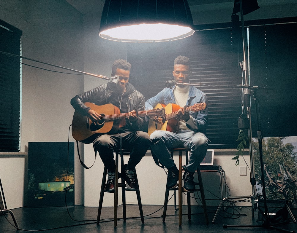 a couple of men sitting next to each other on top of a chair