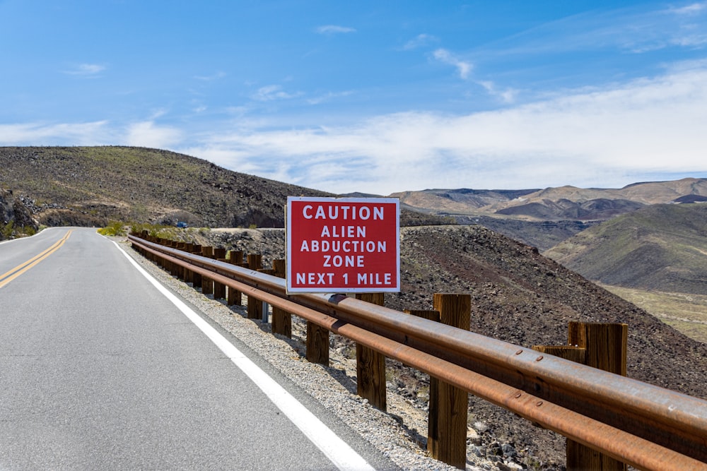 a red caution sign sitting on the side of a road