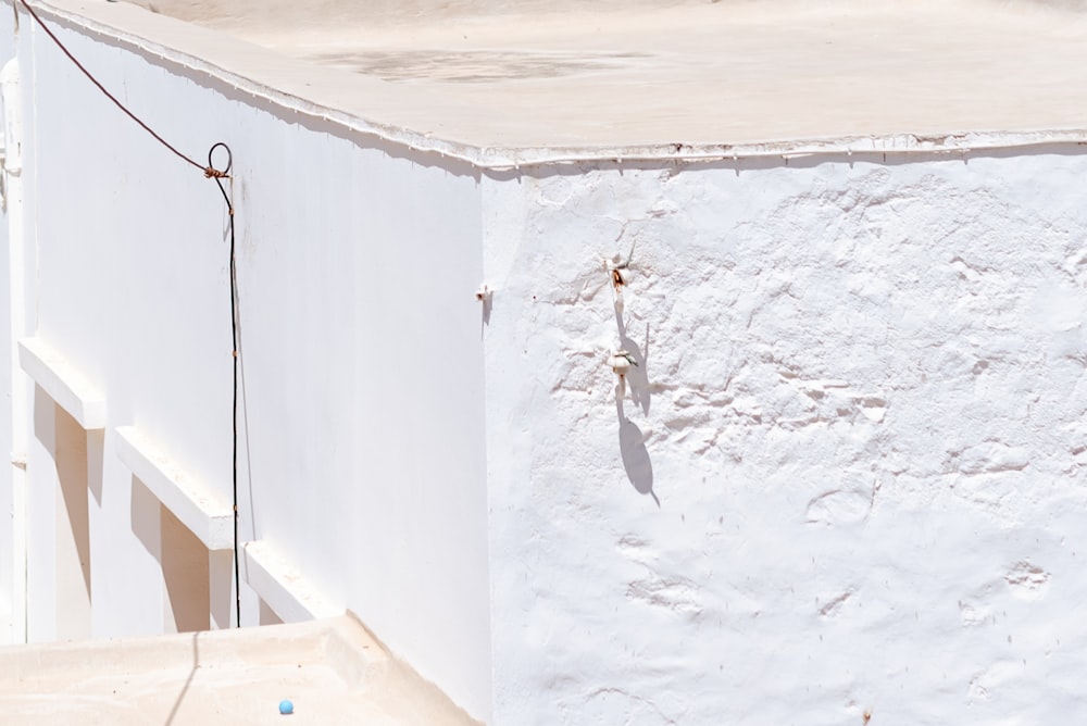 a white building with a blue ball hanging off of it's side