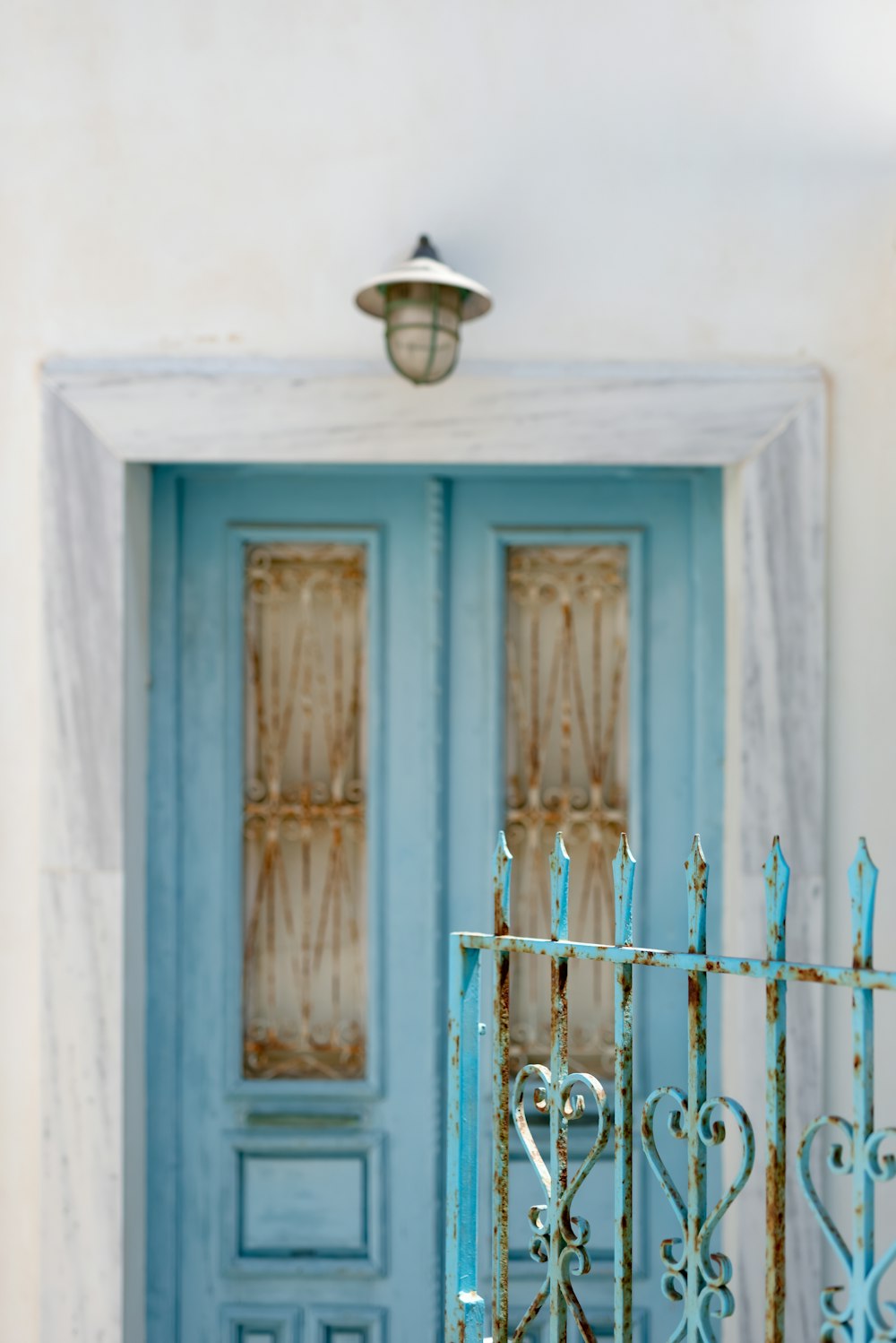 a blue door with a wrought iron fence