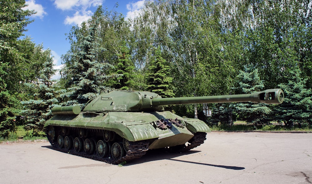 a green tank sitting on top of a parking lot