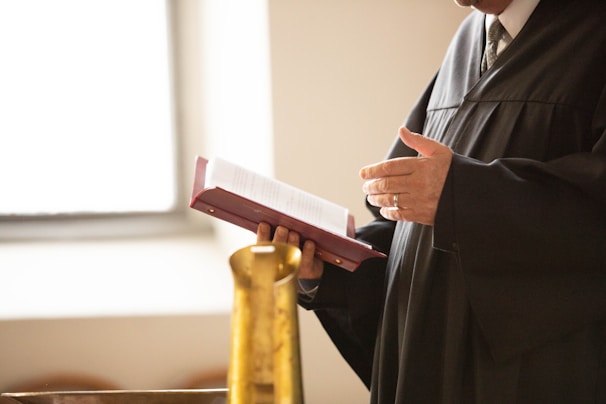 a man in a black robe holding a book