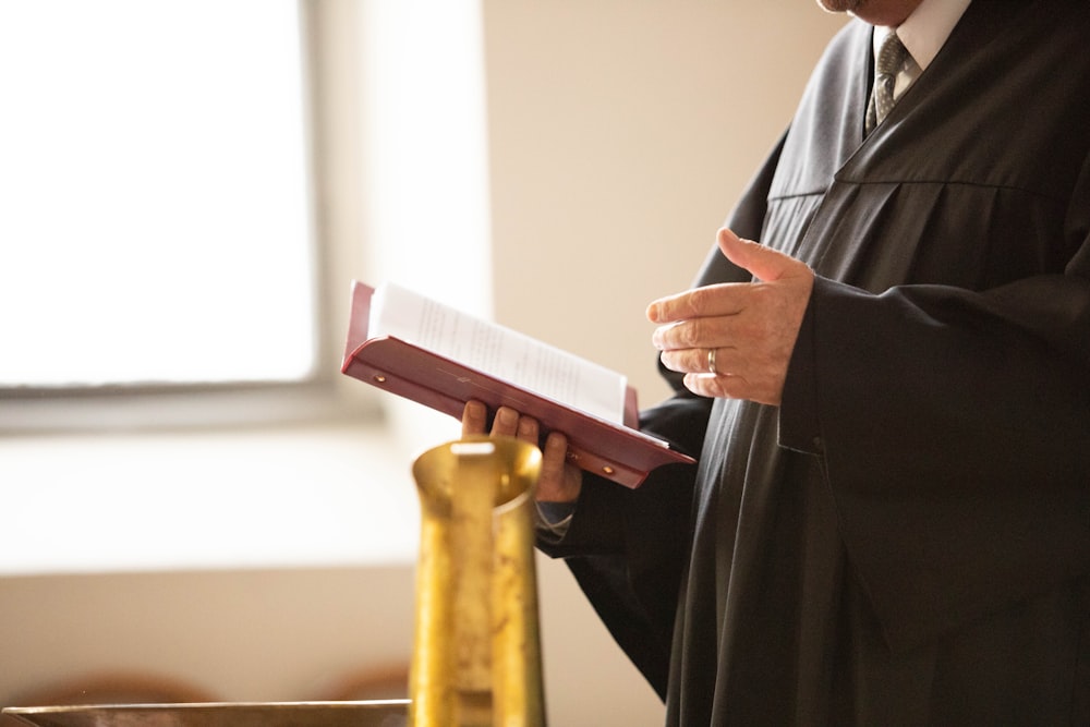 a man in a black robe holding a book