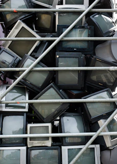 A row of repaired TVs lined up, ready for customer pickup