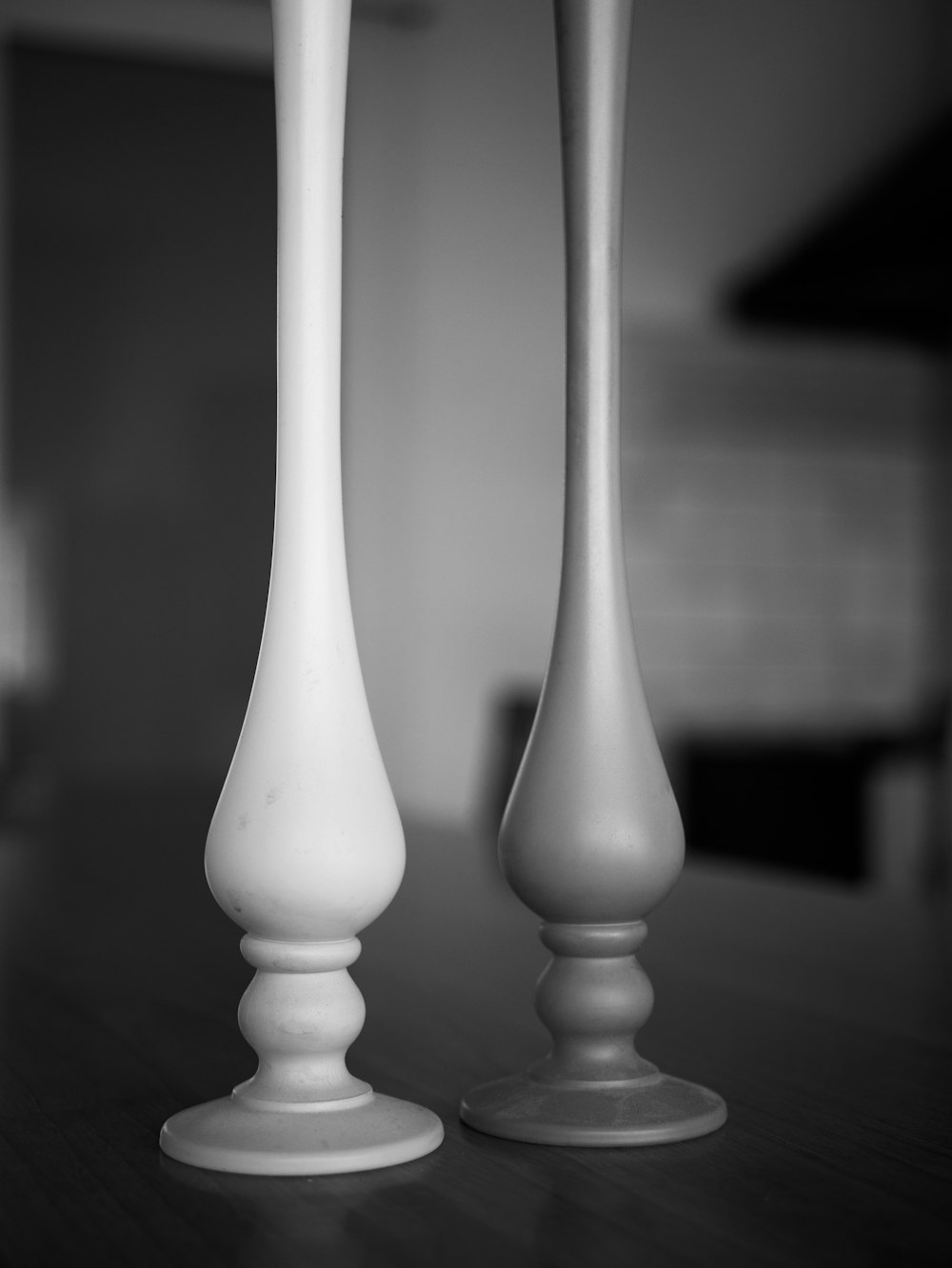 a black and white photo of two white candlesticks