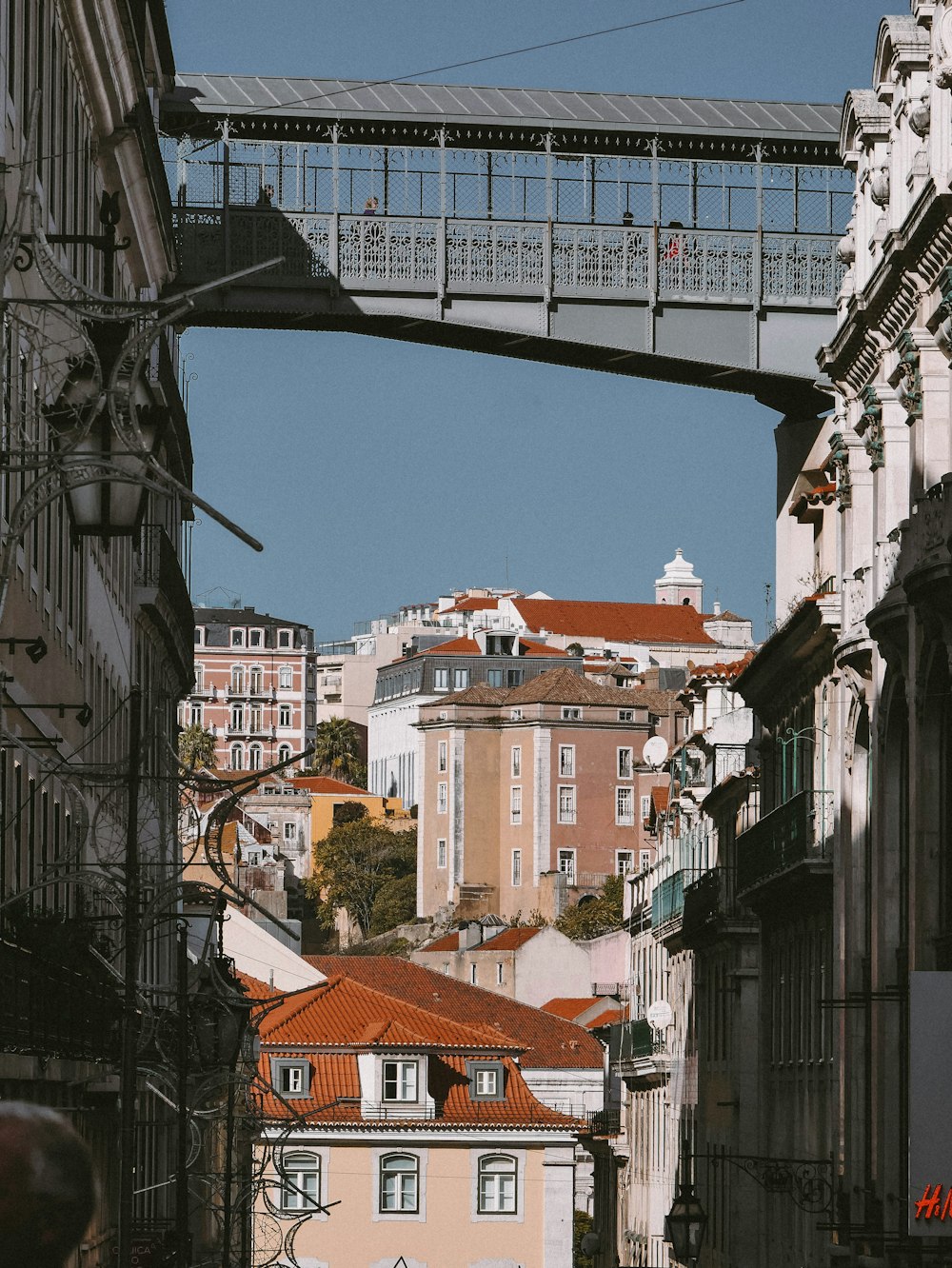 a bridge over a street with buildings in the background