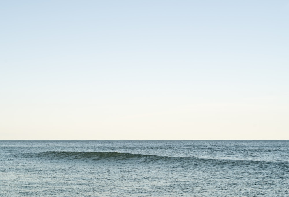 Una persona montando una tabla de surf en una ola en el océano