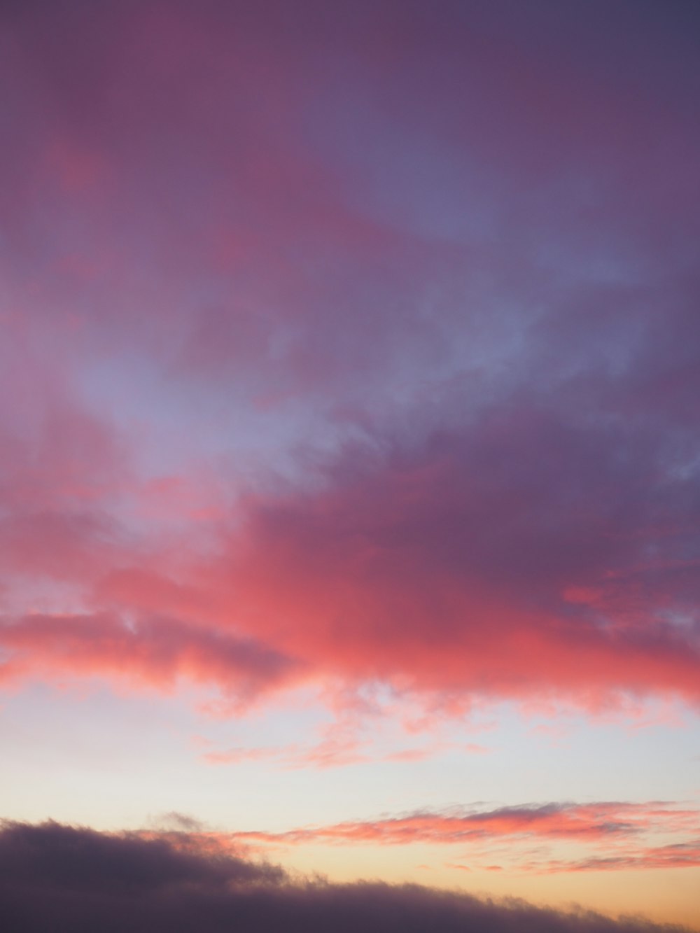 a plane flying in the sky at sunset