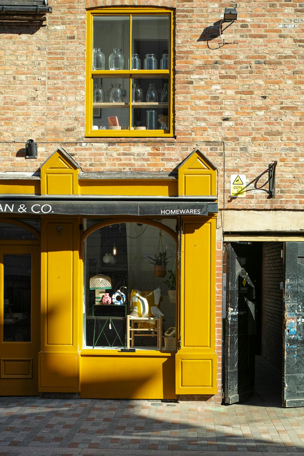 a store front with a yellow awning on a brick building