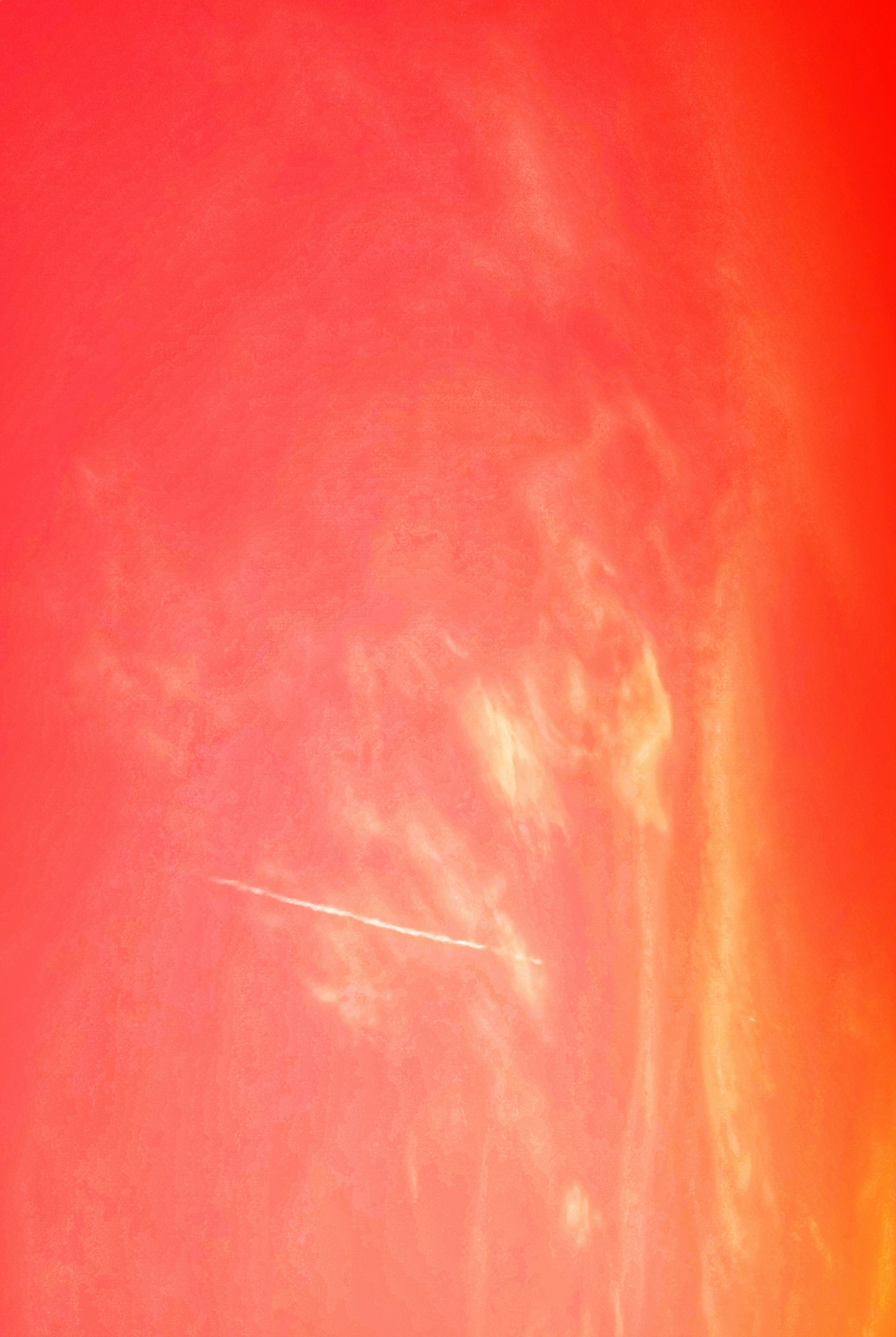 Ein Flugzeug, das mit einem Regenbogen im Hintergrund am Himmel fliegt