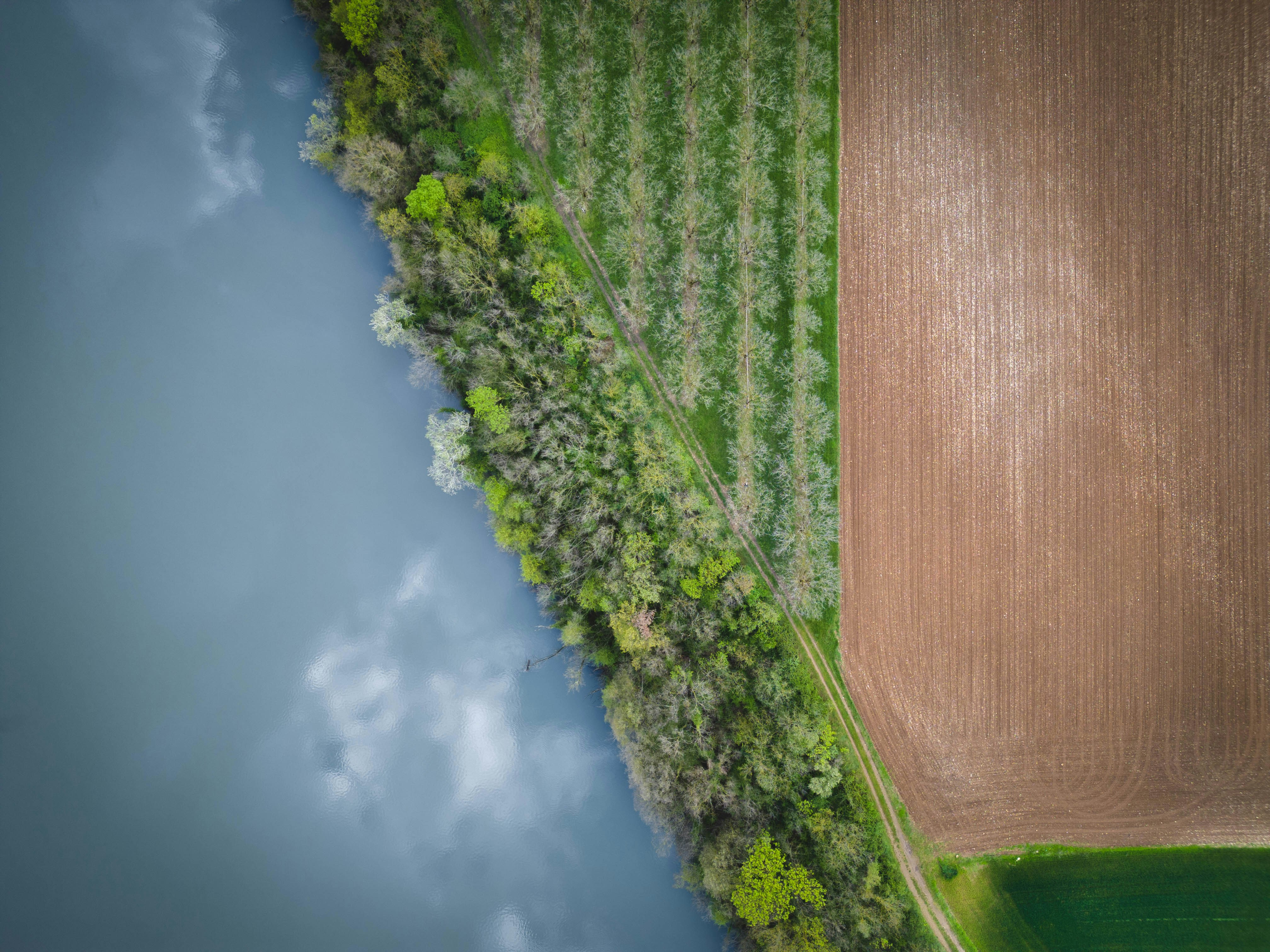An aerial view of a field and a body of water photo – Free River Image ...