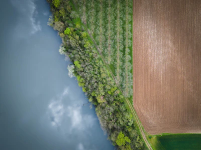 Aerial view of a flat land plot near a small river.