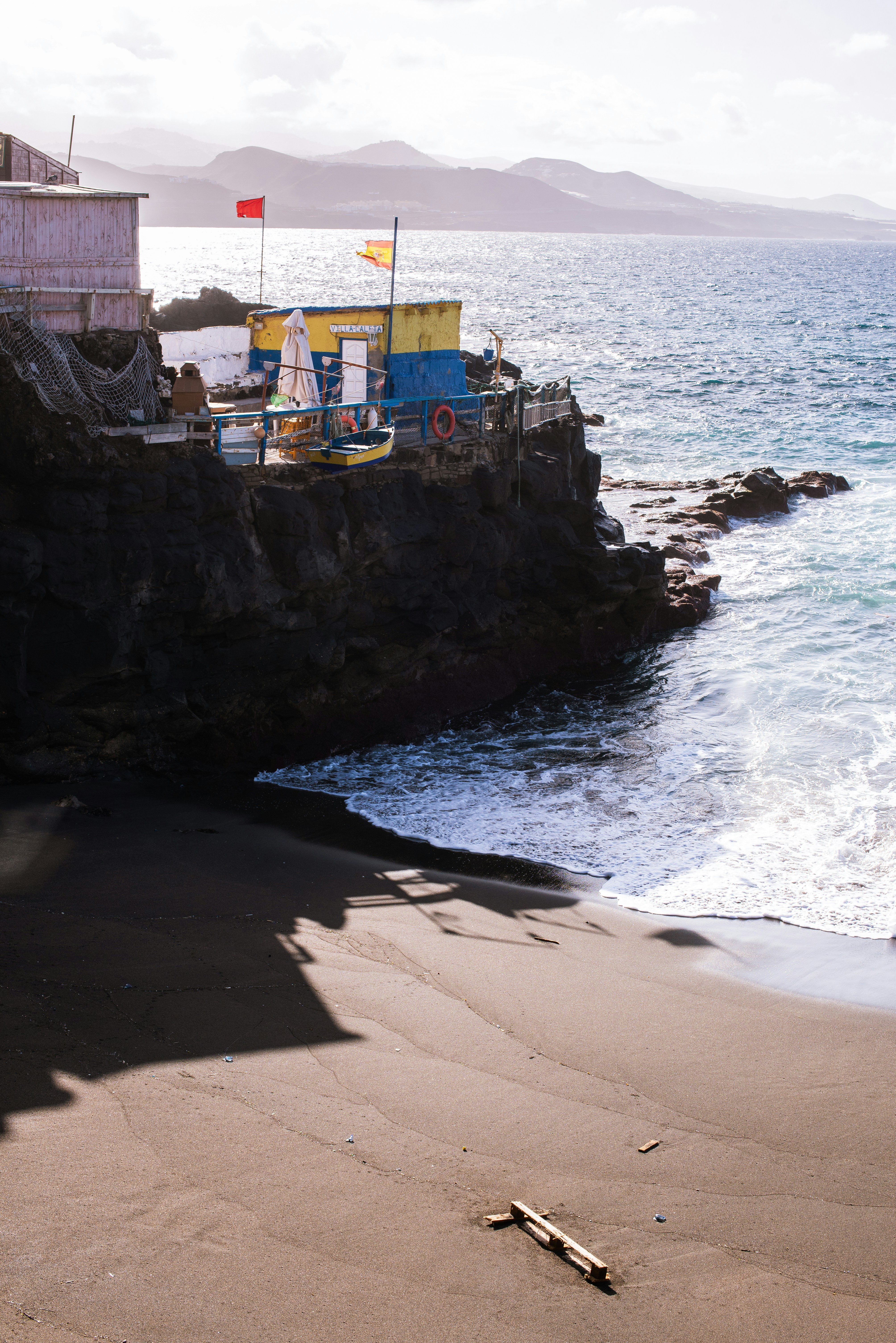 a boat sitting on top of a beach next to the ocean