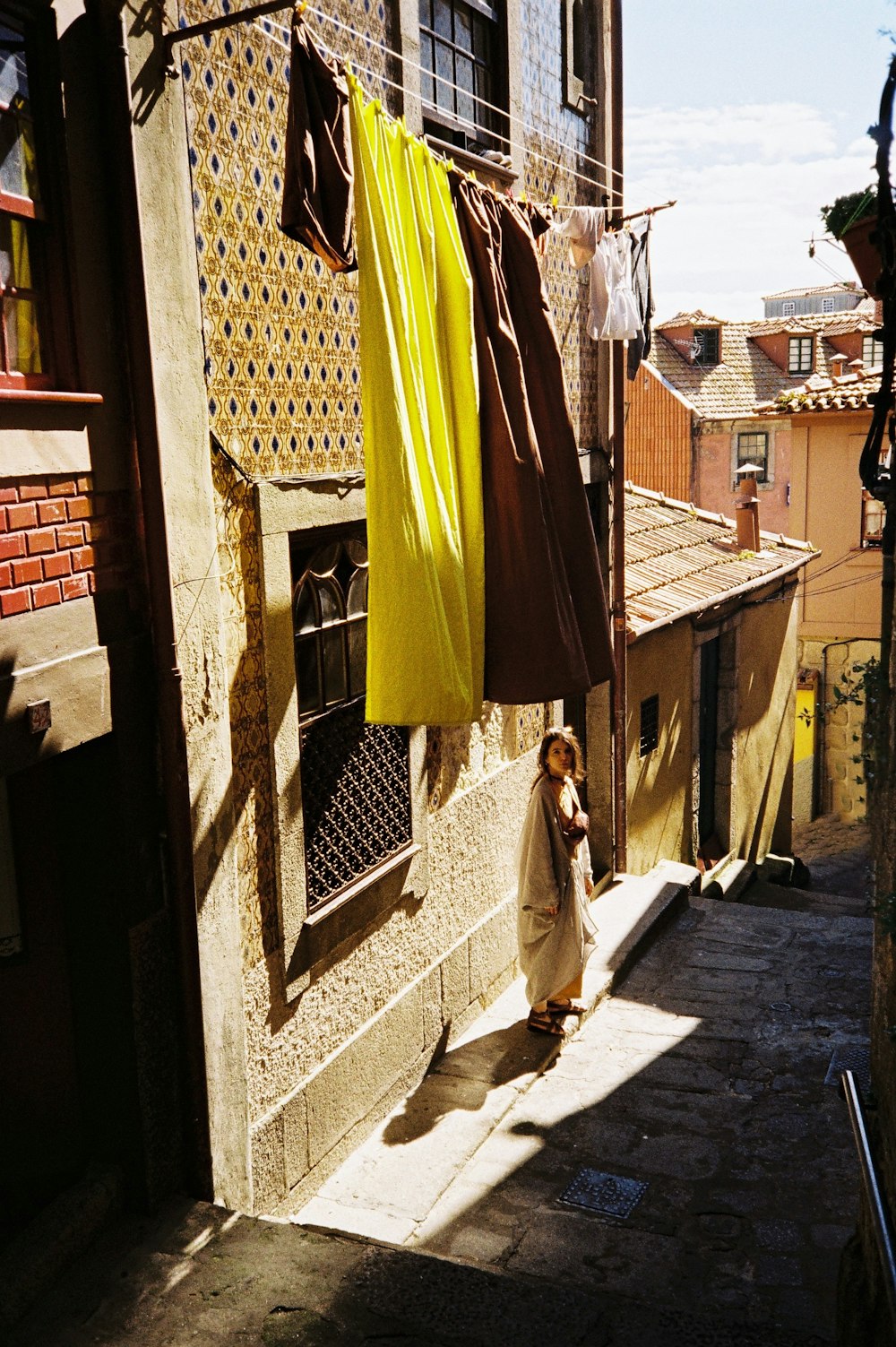 a woman walking down a street next to a building