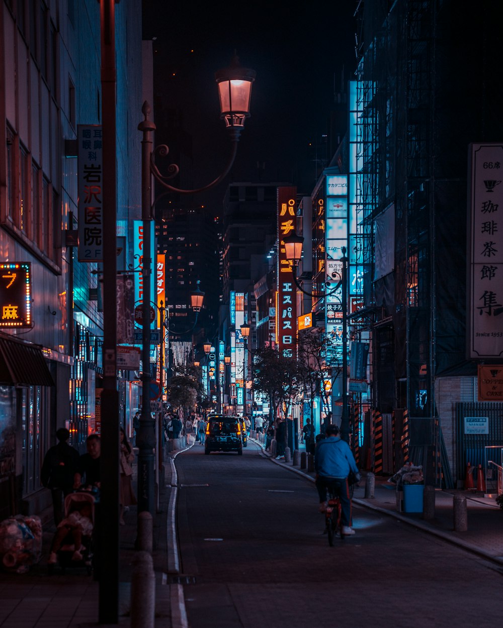 a man riding a bike down a street at night