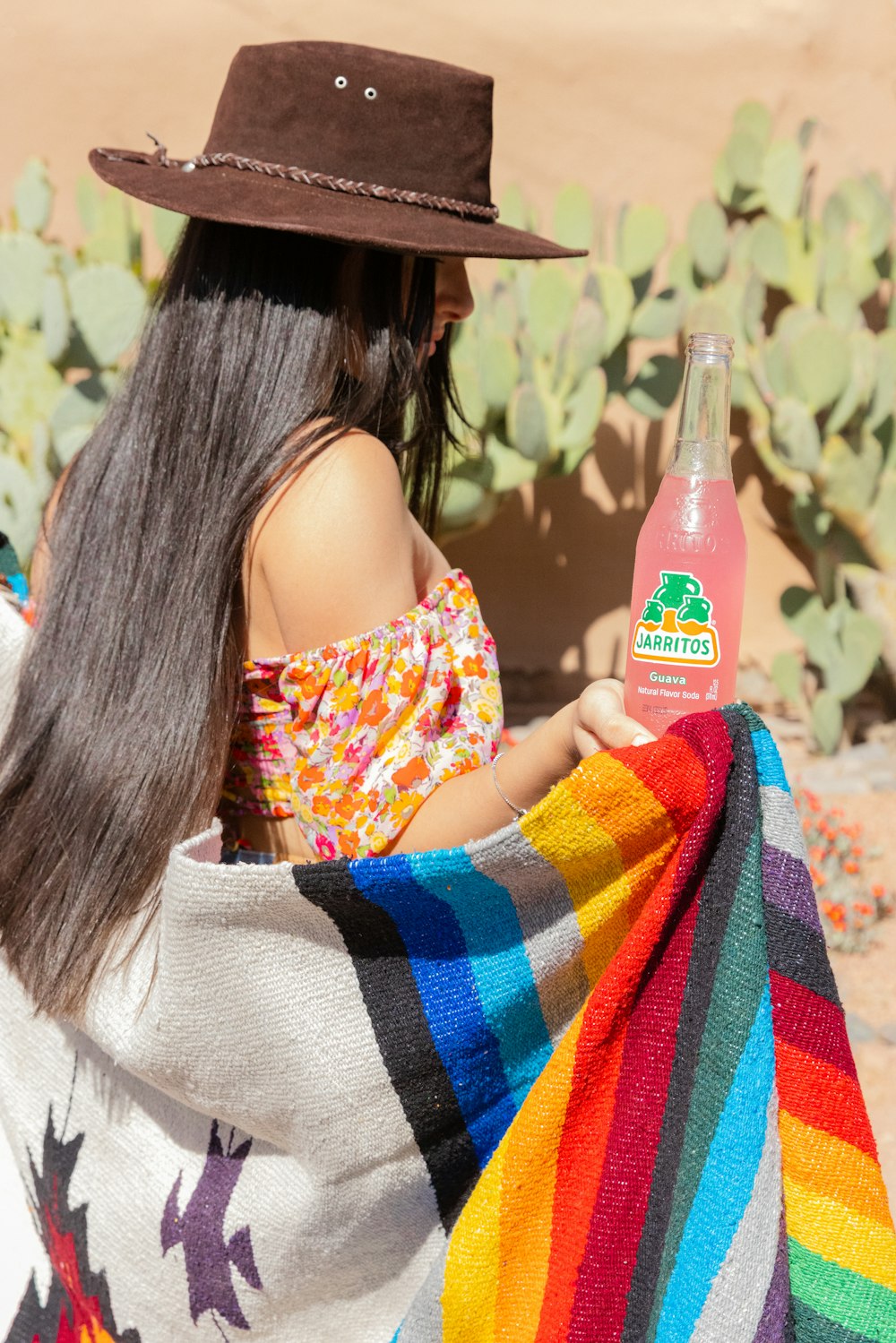 a woman holding a bottle of water wrapped in a blanket