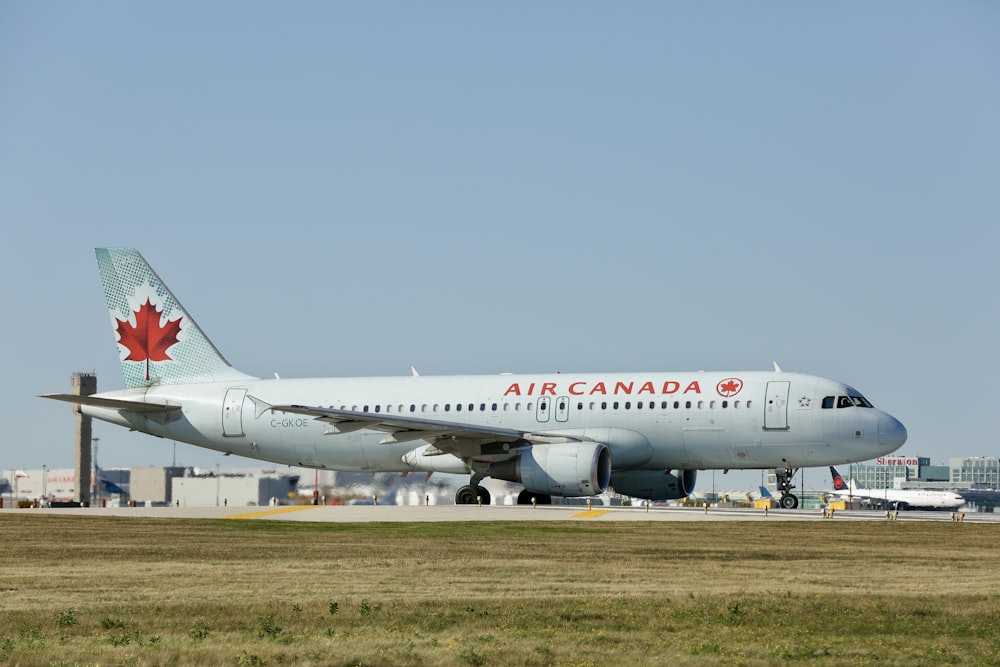 a large air canada jetliner sitting on top of an airport runway