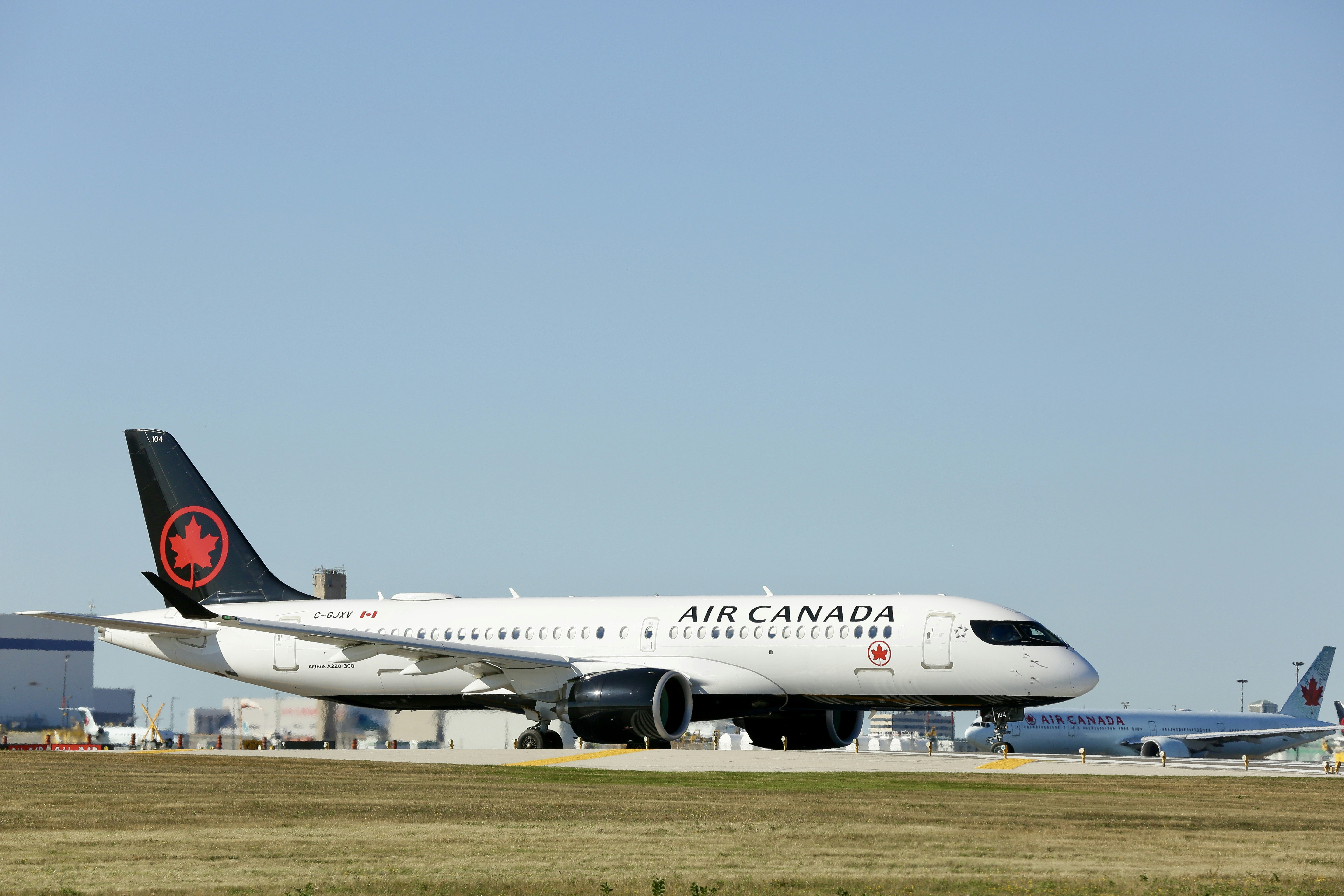 a large air canada jetliner sitting on top of an airport runway