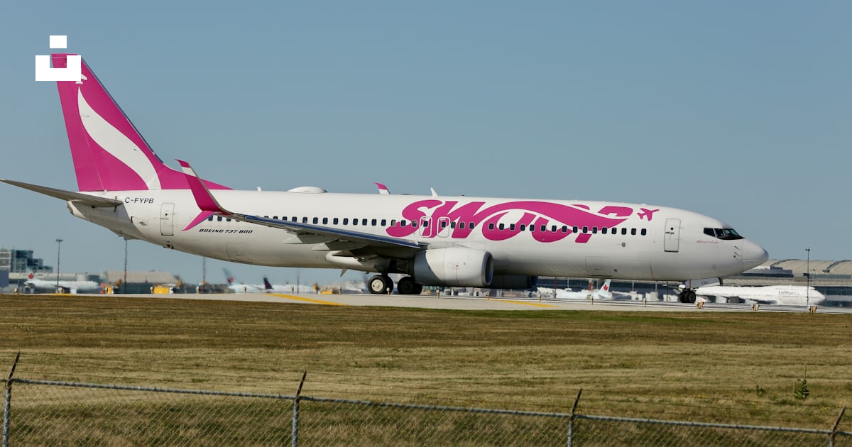 Un avion rose et blanc est sur la piste photo – Photo Aéroport ...