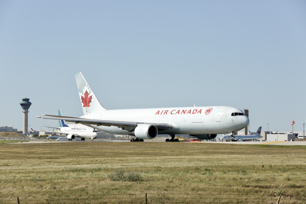 a large air canada jetliner sitting on top of an airport runway