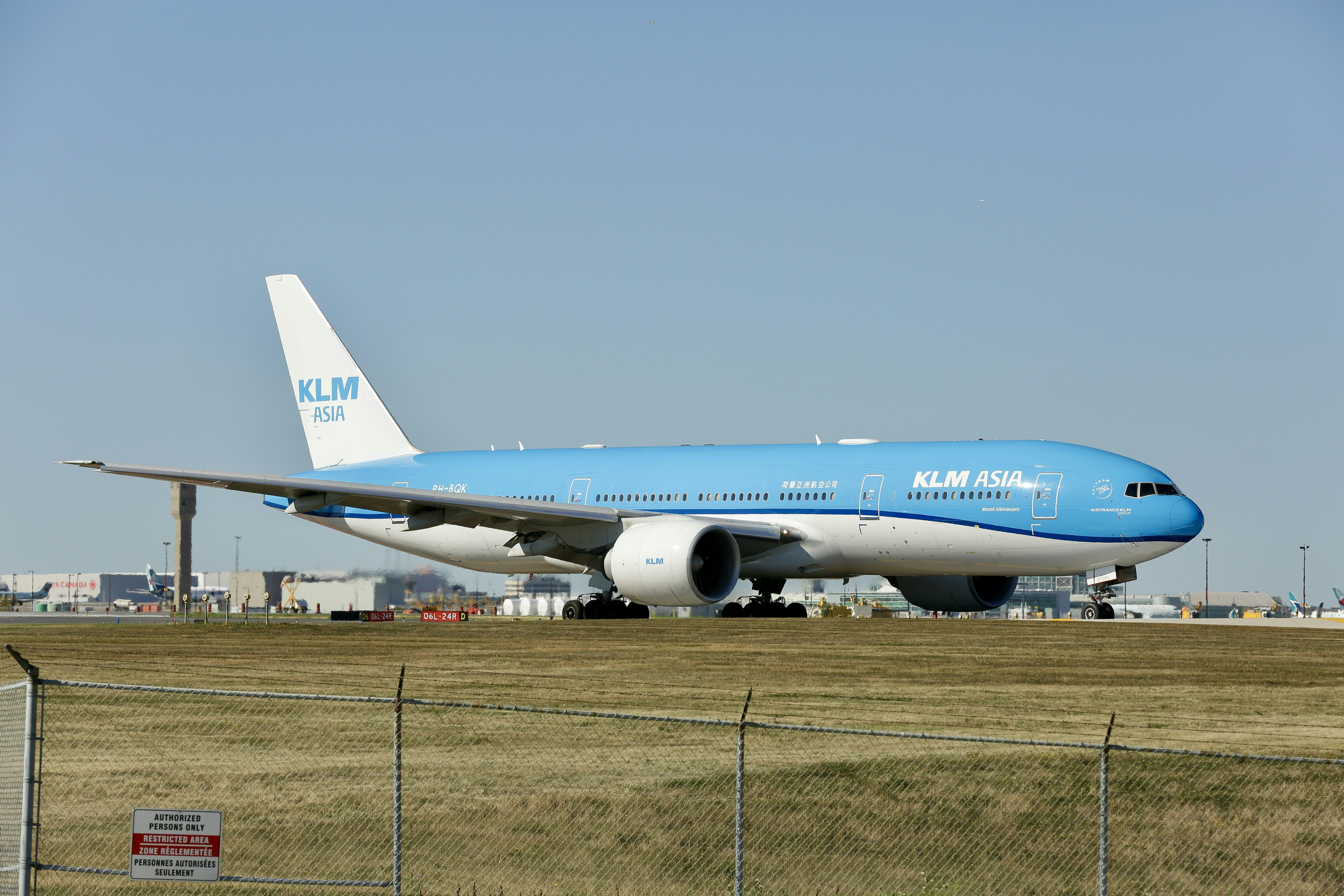a large blue and white jetliner sitting on top of an airport runway, 
