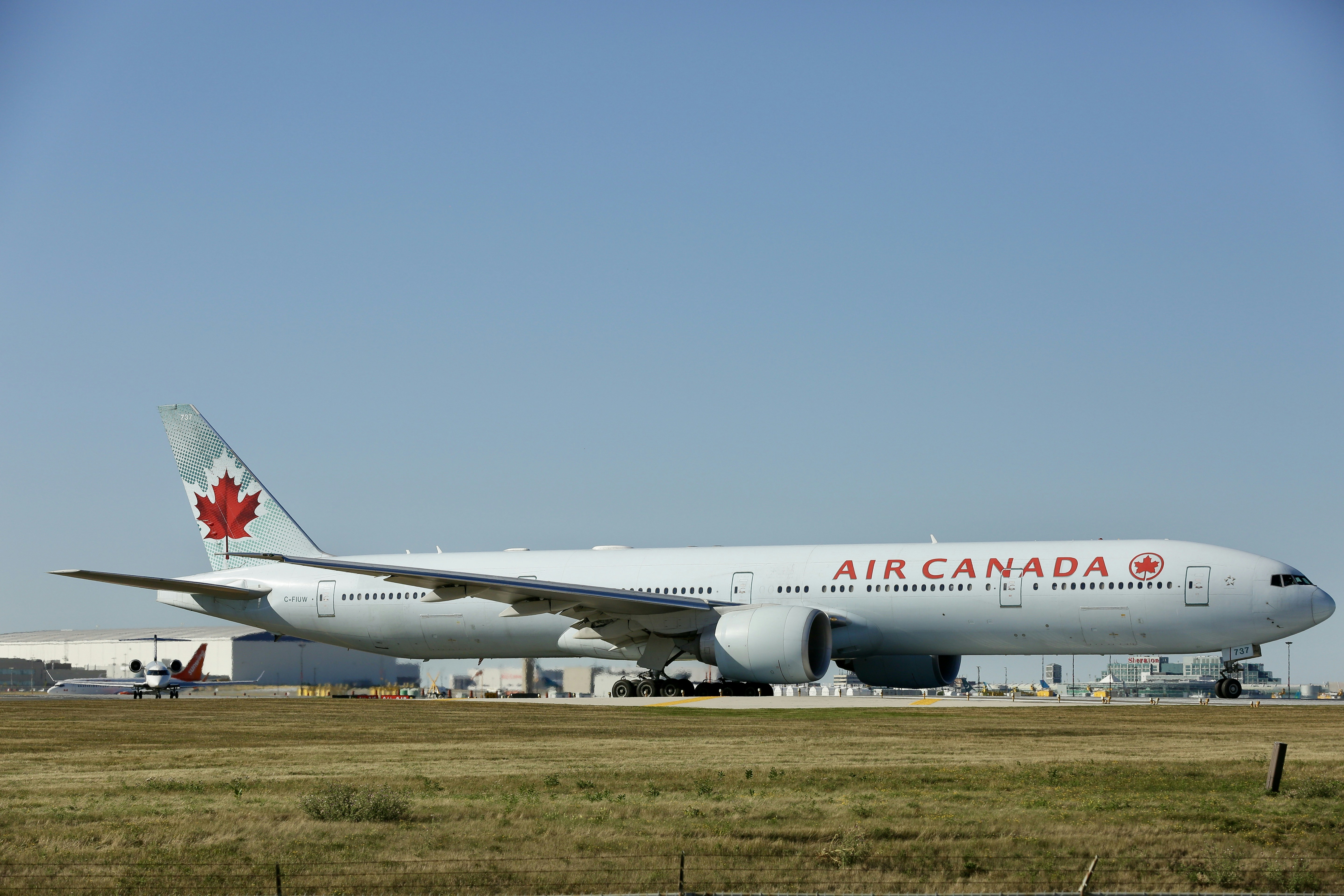 a large air canada jetliner sitting on top of an airport runway, 