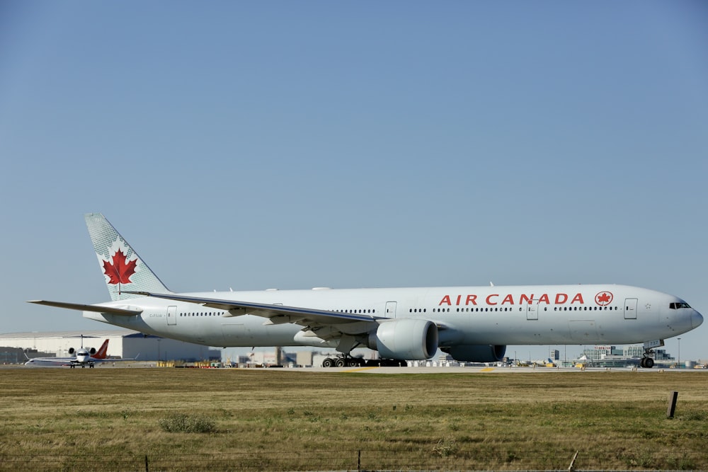 um grande avião canada jetliner sentado em cima de uma pista do aeroporto