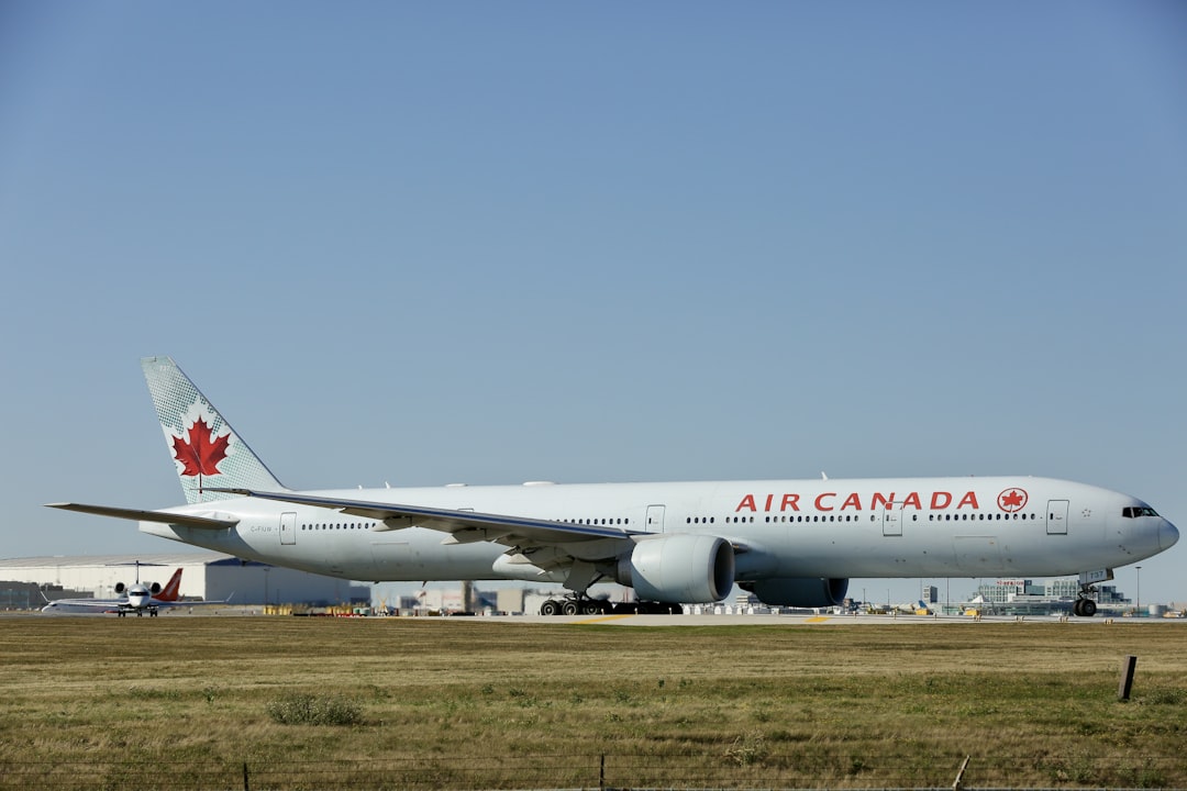 a large air canada jetliner sitting on top of an airport runway,