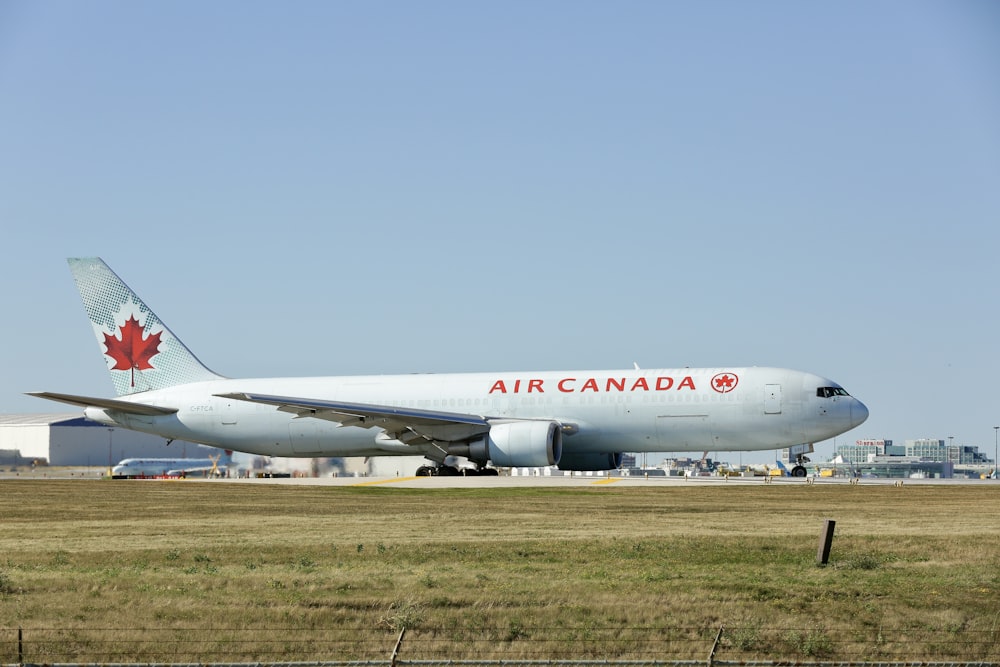 a large air canada jetliner sitting on top of an airport runway