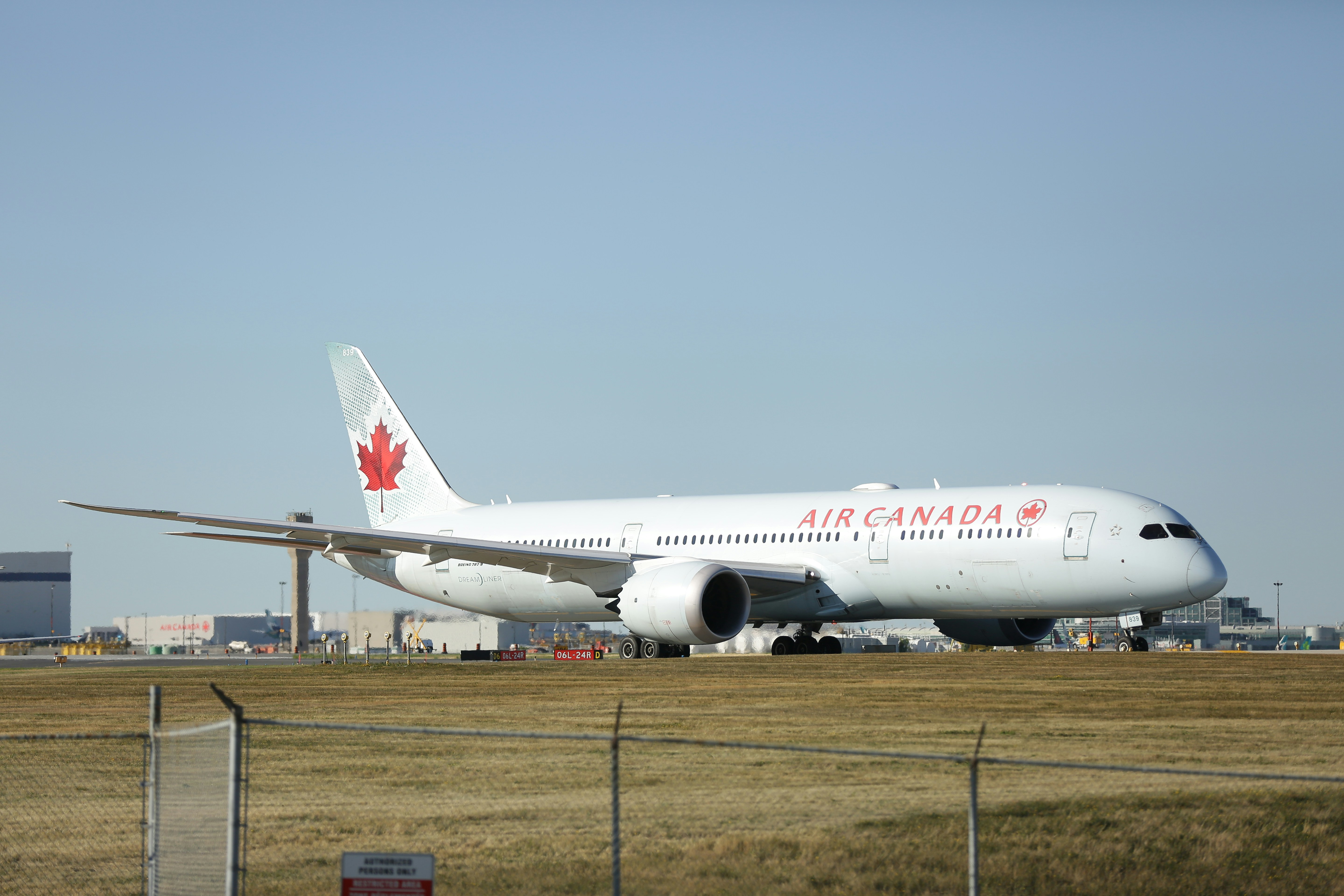 a large air canada jetliner sitting on top of an airport runway
