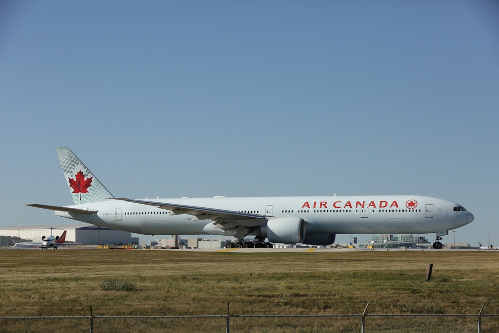 um grande avião canada jetliner sentado em cima de uma pista do aeroporto